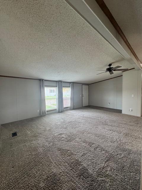 unfurnished room with ceiling fan, carpet, and a textured ceiling