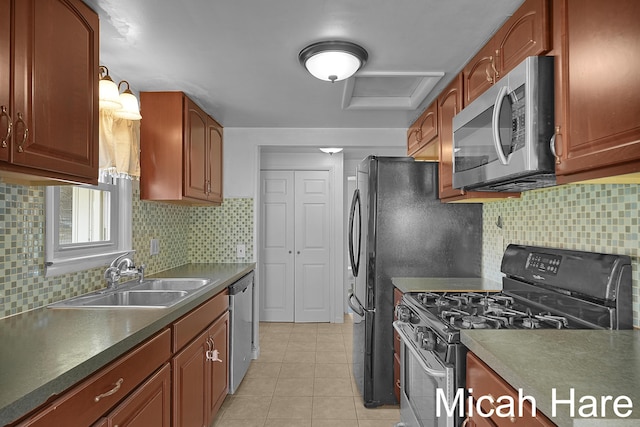 kitchen with dark countertops, tasteful backsplash, a sink, stainless steel appliances, and light tile patterned flooring