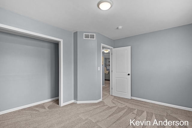 unfurnished bedroom featuring baseboards, carpet floors, and visible vents