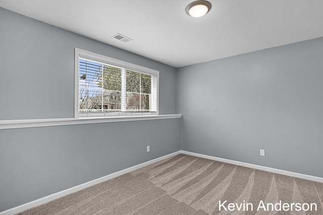 empty room featuring baseboards, carpet, and visible vents