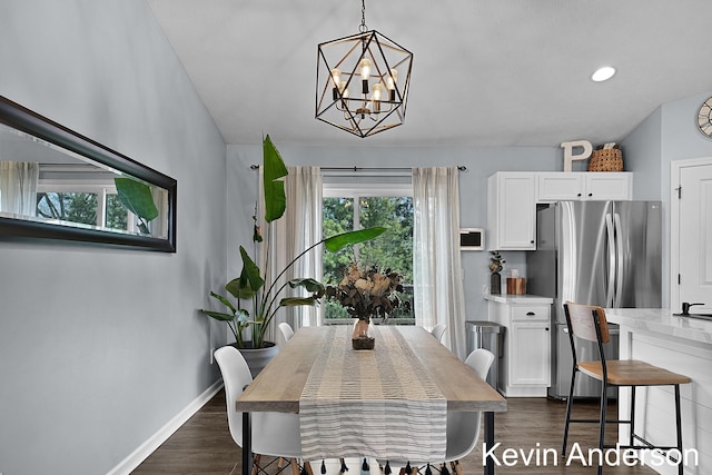 dining space featuring dark wood-type flooring, baseboards, and a chandelier