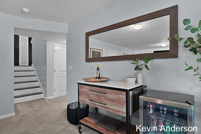 bar featuring carpet flooring, a textured ceiling, wine cooler, and stairs