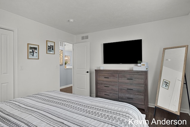 bedroom featuring baseboards, visible vents, and dark wood-style floors