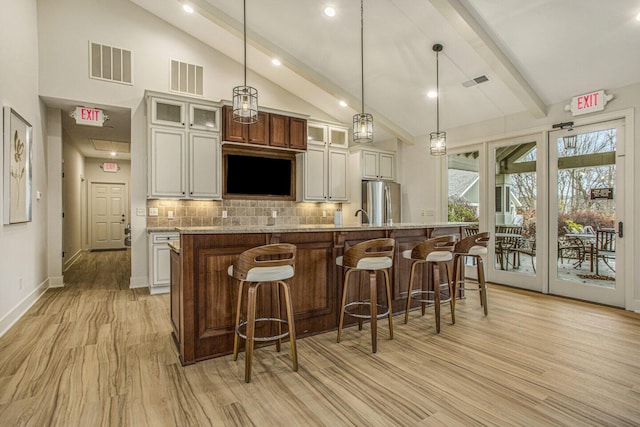 kitchen with freestanding refrigerator, visible vents, decorative backsplash, and beam ceiling