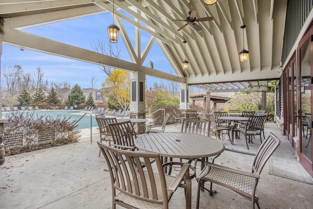 view of patio with outdoor dining area, ceiling fan, and a community pool
