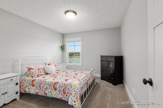 carpeted bedroom featuring baseboards and a textured ceiling