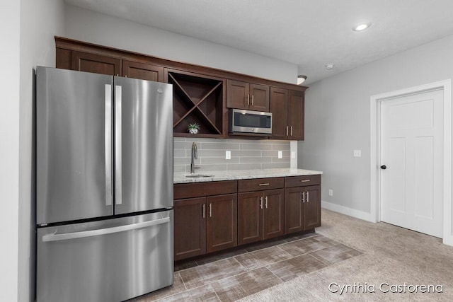 kitchen featuring appliances with stainless steel finishes, tasteful backsplash, open shelves, dark brown cabinets, and a sink