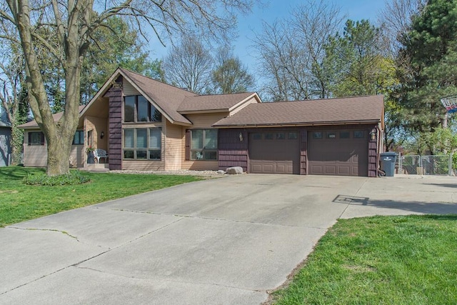 view of front of home with fence, roof with shingles, an attached garage, a front lawn, and driveway