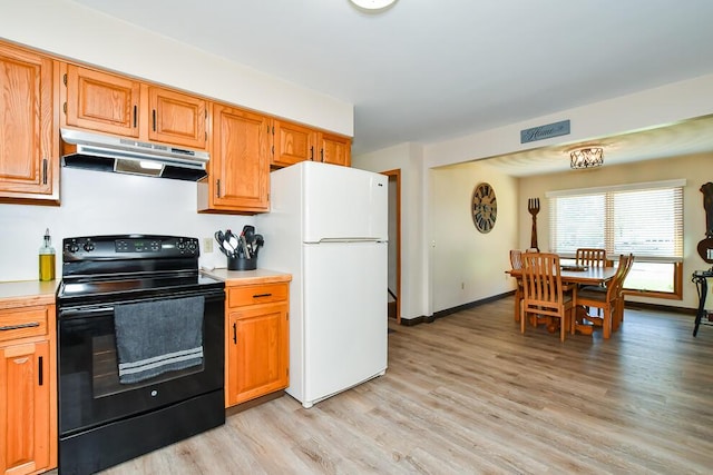 kitchen featuring under cabinet range hood, electric range, freestanding refrigerator, and light countertops