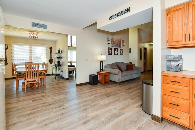 living area with visible vents, light wood-style floors, and baseboards