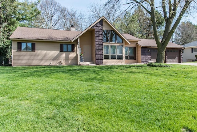 view of front of property with a front yard, roof with shingles, a chimney, concrete driveway, and an attached garage