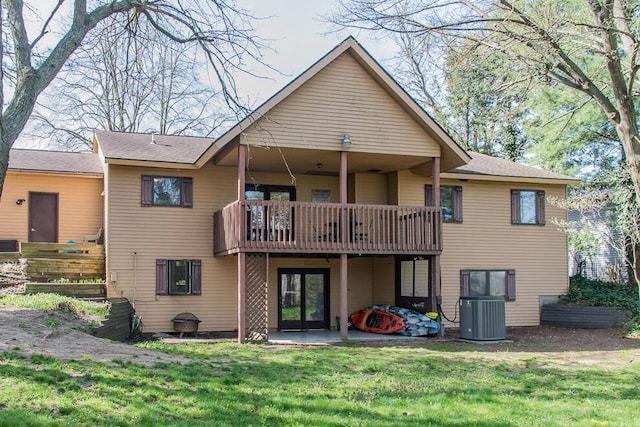 rear view of property with central air condition unit, a lawn, a patio area, and a balcony
