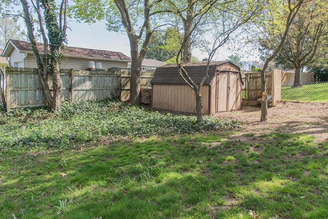 view of yard with a storage shed, an outbuilding, and a fenced backyard