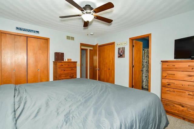 bedroom with ceiling fan, multiple closets, carpet, and visible vents