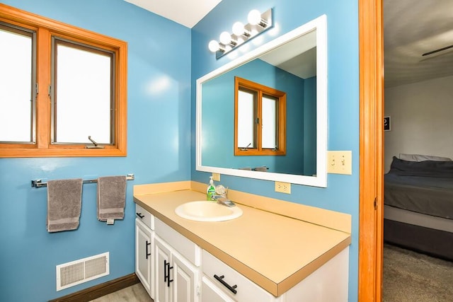 ensuite bathroom featuring visible vents, connected bathroom, and vanity
