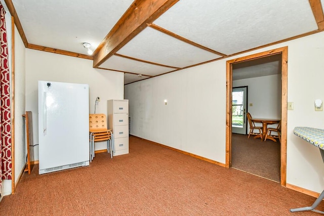 below grade area with baseboards, freestanding refrigerator, and carpet