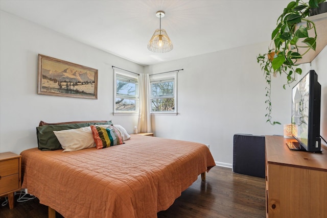 bedroom with baseboards and dark wood-type flooring