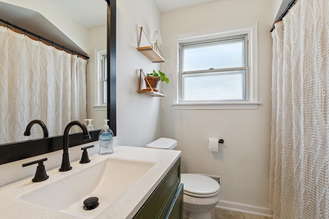 bathroom featuring vanity, baseboards, and toilet