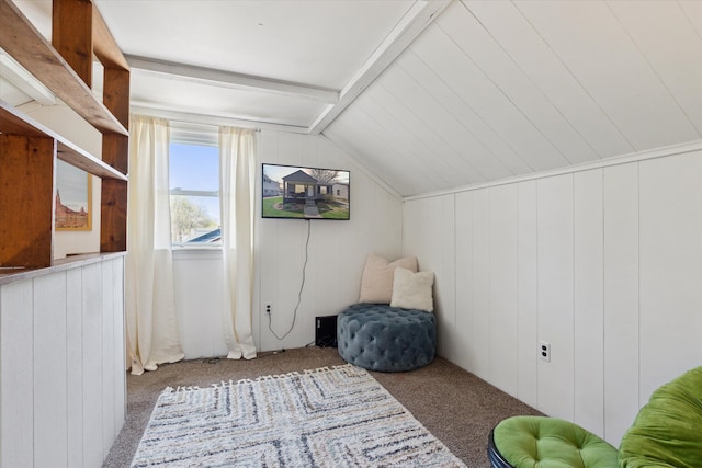 interior space featuring carpet floors, wooden walls, and vaulted ceiling with beams