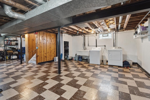 below grade area with a sink, tile patterned floors, and washing machine and dryer