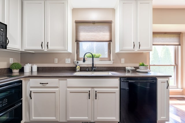 1229 Poppy Hill Dr, Oxford, MI 48371 - kitchen with black dishwasher, dark countertops, plenty of natural light, and a sink