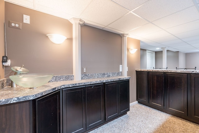 1229 Poppy Hill Dr, Oxford, MI 48371 - kitchen featuring decorative columns, light colored carpet, light countertops, a paneled ceiling, and a sink