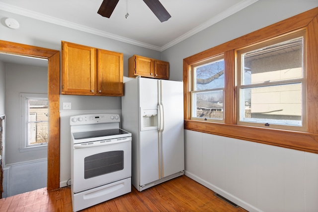 kitchen featuring plenty of natural light, wood finished floors, and white appliances