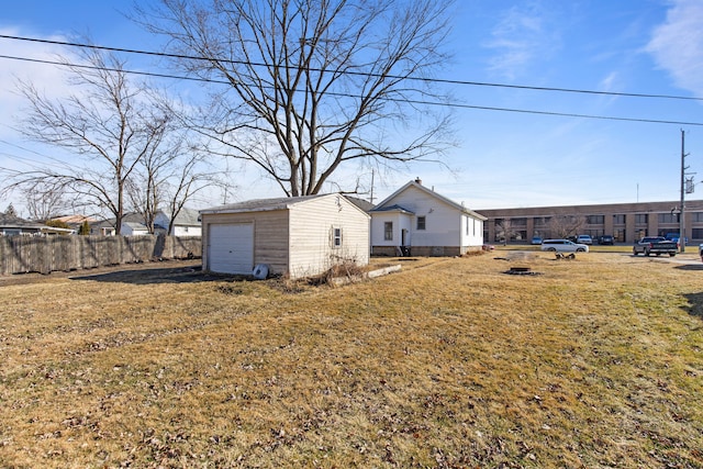 view of yard featuring fence, an outdoor structure, and a garage