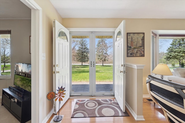 foyer featuring baseboards, french doors, and wood finished floors