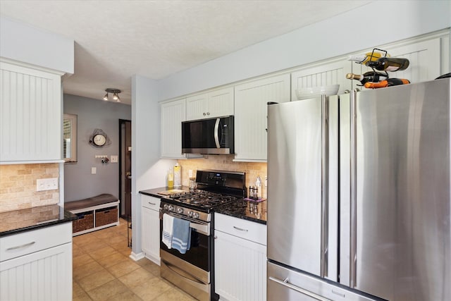 kitchen featuring decorative backsplash, appliances with stainless steel finishes, and white cabinets