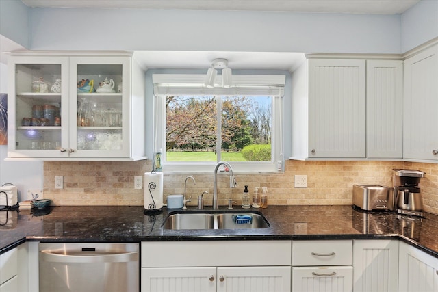 kitchen with stainless steel dishwasher, a sink, decorative backsplash, and white cabinets