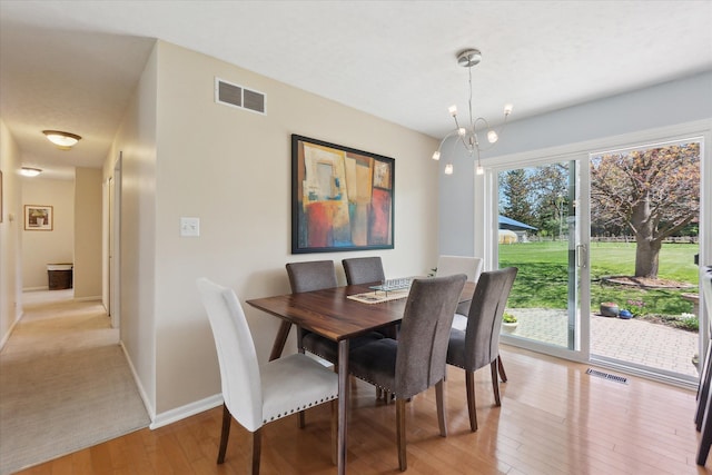dining area featuring visible vents, light wood finished floors, and baseboards