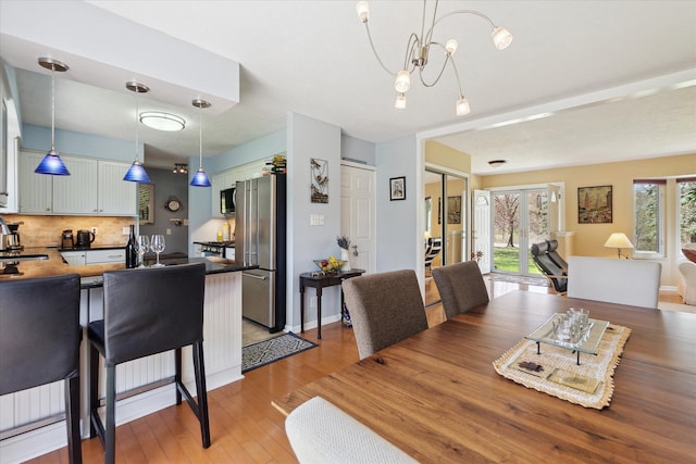 dining room with a notable chandelier and light wood-style floors