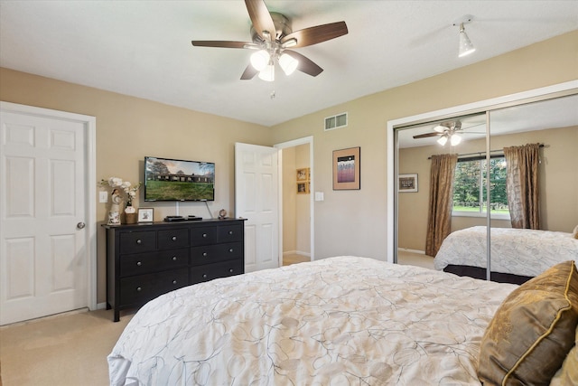 carpeted bedroom with baseboards, ceiling fan, a closet, and visible vents