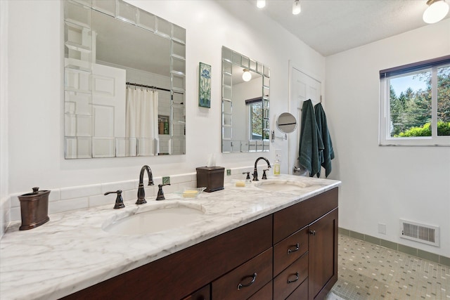 bathroom featuring a sink, a shower with shower curtain, double vanity, and visible vents