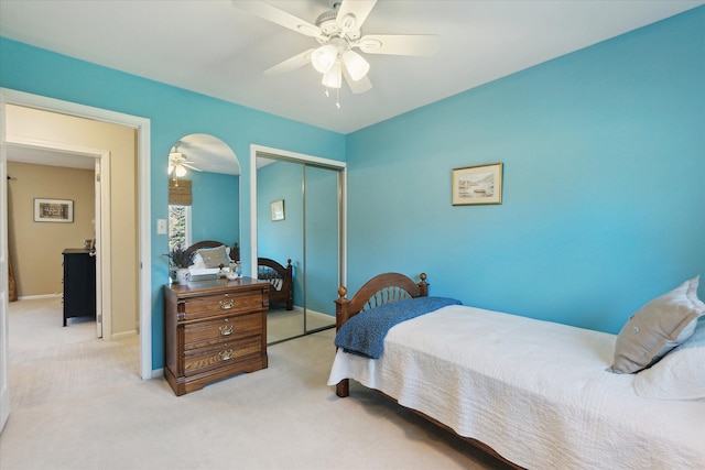 bedroom with baseboards, ceiling fan, a closet, and carpet flooring