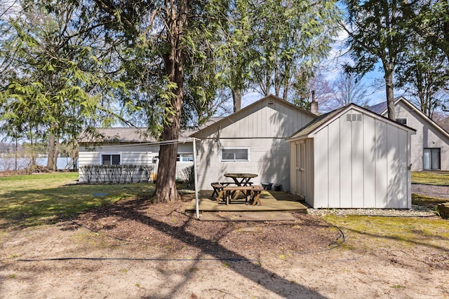 rear view of house with a storage unit, an outdoor structure, and a lawn