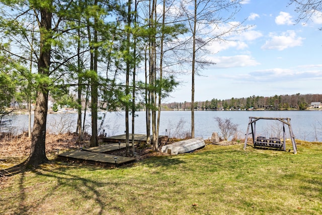 dock area with a lawn and a water view