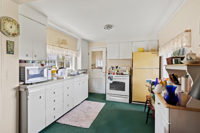 kitchen featuring white appliances, light countertops, white cabinets, and dark colored carpet