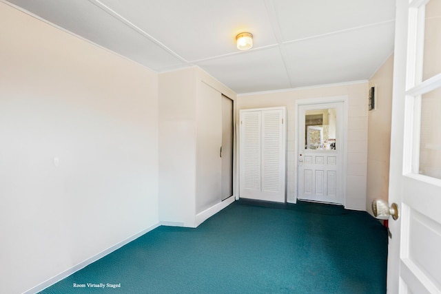 spare room with dark colored carpet and baseboards