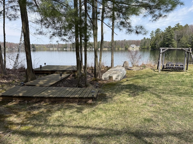 dock area featuring a lawn and a water view