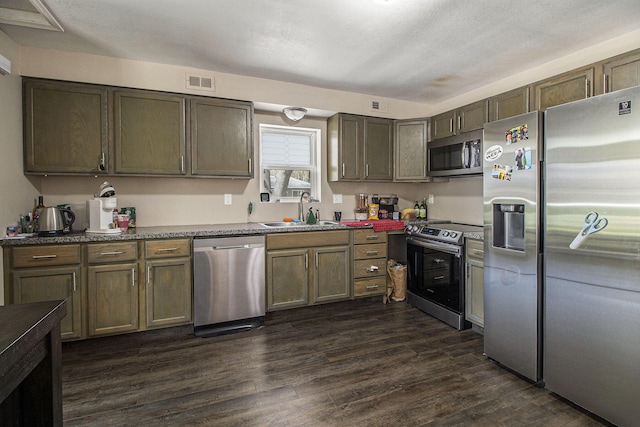 kitchen featuring a sink, appliances with stainless steel finishes, dark wood-style floors, and visible vents