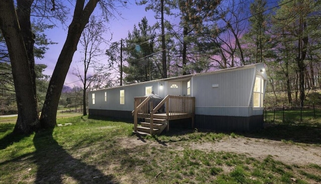 view of front of house with a deck and a front lawn