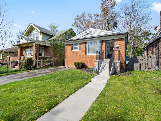 bungalow-style home with brick siding, a front lawn, and fence