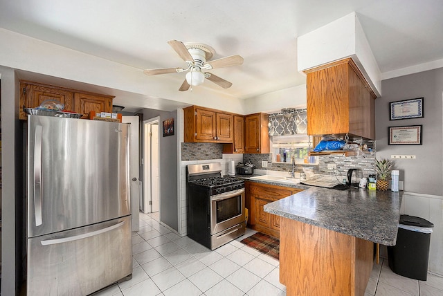 18643 Bittersweet, Fraser, MI 48026 - kitchen featuring appliances with stainless steel finishes, a peninsula, brown cabinets, tasteful backsplash, and a ceiling fan
