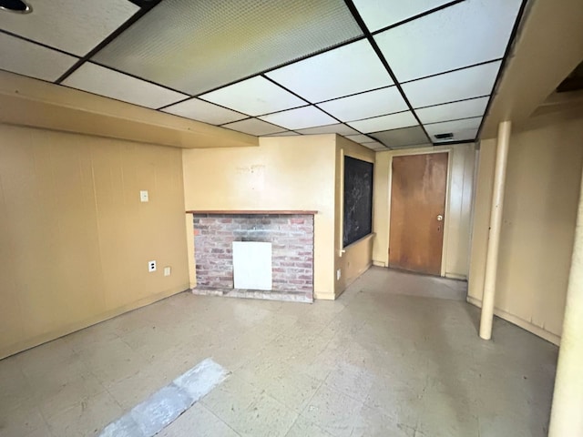 finished below grade area featuring baseboards and a paneled ceiling