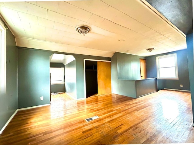 interior space with arched walkways, hardwood / wood-style floors, and visible vents