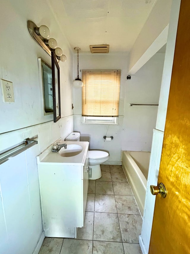 bathroom featuring tile patterned floors, toilet, vanity, and a bath