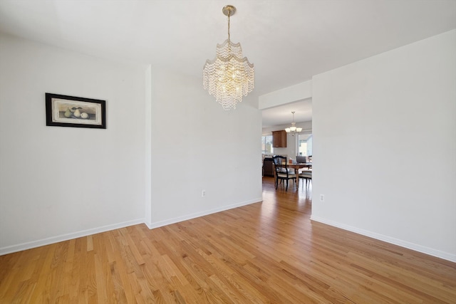 61 Old Carriage Ln, Lapeer, MI 48446 - unfurnished dining area featuring baseboards, a notable chandelier, and light wood-type flooring