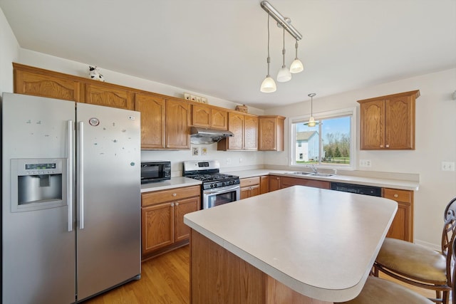 61 Old Carriage Ln, Lapeer, MI 48446 - kitchen featuring a kitchen bar, appliances with stainless steel finishes, hanging light fixtures, a sink, and under cabinet range hood